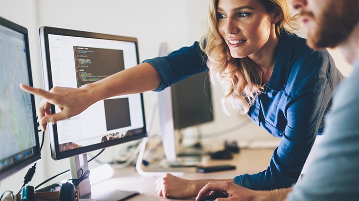 En kvinde viser en mand noget på skærm hvor der er vist Dynamics 365